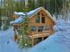 Charming log cabin with snow-covered surroundings and inviting wooden deck, perfect for mountain living at 812 High Point Dr, Breckenridge, CO 80424