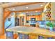 Spacious kitchen with tile countertops, wooden cabinetry, breakfast bar, and adjacent staircase, perfect for gatherings at 812 High Point Dr, Breckenridge, CO 80424