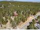 Aerial view of the house nestled in a lush, green forest at 767 Tenderfoot Dr, Larkspur, CO 80118