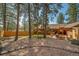 Landscaped backyard with patio and mature trees offer a private outdoor space at 767 Tenderfoot Dr, Larkspur, CO 80118