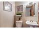 Cozy powder room with pedestal sink, decorative art, and updated fixtures at 767 Tenderfoot Dr, Larkspur, CO 80118