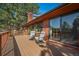 Spacious deck with comfortable seating and scenic views of the surrounding trees and landscape at 767 Tenderfoot Dr, Larkspur, CO 80118