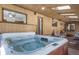 Indoor hot tub room with wood paneled walls, skylights, and adjacent lounge area at 767 Tenderfoot Dr, Larkspur, CO 80118