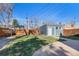 Large backyard with a detached garage, grass, and a stone garden, perfect for outdoor enjoyment at 3931 King St, Denver, CO 80211