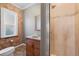 Rustic bathroom featuring exposed brick, vanity with sink, and tiled shower at 3931 King St, Denver, CO 80211