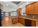 Open kitchen showcasing wood cabinetry, tile floors, granite counters, breakfast bar, and connection to the living room at 3931 King St, Denver, CO 80211