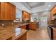 A functional kitchen with wood cabinets, granite countertops, tile backsplash, and tile flooring at 3931 King St, Denver, CO 80211