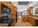 A well-equipped kitchen features a black oven, wood cabinets, granite countertops, and tile floors at 3931 King St, Denver, CO 80211