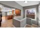 View from staircase to kitchen featuring wood cabinets, granite countertops, breakfast bar, and connection to living room at 3931 King St, Denver, CO 80211