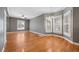 Bright living room featuring hardwood floors, neutral paint, and large bay windows with plantation shutters at 3931 King St, Denver, CO 80211