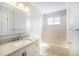 Bright bathroom featuring tile flooring, a tub and shower combination, and a vanity with storage, combining style and functionality at 9712 Adams St, Thornton, CO 80229