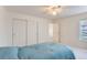 Bedroom with carpet floors, a ceiling fan, two closets, and a large window at 9758 Laredo St # 1E, Commerce City, CO 80022
