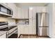 Well-equipped kitchen featuring stainless steel appliances, white cabinets, and granite countertops at 9758 Laredo St # 1E, Commerce City, CO 80022