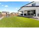 Wide view of backyard with covered patio, artificial turf and wooden fence at 140 Vista Cliff Cir, Castle Rock, CO 80104