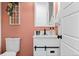 Stylish powder room featuring a peach wall, white vanity and a decorative mirror at 140 Vista Cliff Cir, Castle Rock, CO 80104