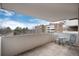 Open-air balcony with a table and chairs and view of the building and the surrounding trees at 2880 S Locust St # 505N, Denver, CO 80222