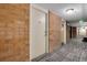 Apartment hallway with carpet, brick accent wall, and recessed lighting at 2880 S Locust St # 505N, Denver, CO 80222