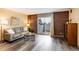 Stylish living room boasts a brick accent wall, balcony access and modern wood-look flooring at 2880 S Locust St # 505N, Denver, CO 80222