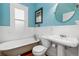 Bathroom with tub, toilet, pedestal sink, and wainscoting at 3182 W 29Th Ave, Denver, CO 80211