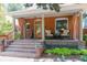 Inviting front porch with seating, brick stairs, and decorative plants and curtains at 3182 W 29Th Ave, Denver, CO 80211