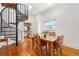 Open living room with hardwood floors, dining table and spiral staircase leading to the kitchen at 3182 W 29Th Ave, Denver, CO 80211