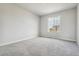 A bright bedroom with a plush carpet, a window overlooking the neighborhood, and neutral-colored walls at 4255 Gozzer Ranch Dr, Elizabeth, CO 80107