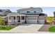 Charming gray two-story home features a welcoming porch, a two-car garage, and meticulous landscaping at 4255 Gozzer Ranch Dr, Elizabeth, CO 80107