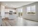 Open concept kitchen with white cabinetry and stainless appliances extends to a spacious living area at 4255 Gozzer Ranch Dr, Elizabeth, CO 80107