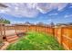 The backyard includes a wooden fence that surrounds a grass area with a wooden deck at 598 Arden Cir, Highlands Ranch, CO 80126