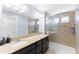 Bathroom with a shower, double sink, granite countertop, and vanity mirror at 10569 Racine St, Commerce City, CO 80022