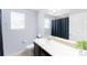 Well-lit bathroom featuring a single sink, toilet, and shower with curtain at 10569 Racine St, Commerce City, CO 80022