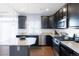 Modern kitchen with stainless steel appliances, granite countertops, and dark wood cabinetry at 10569 Racine St, Commerce City, CO 80022