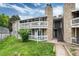 Condo exterior with gray siding, stone accents, and a well-maintained green lawn at 18103 E Kentucky Ave # 103, Aurora, CO 80017