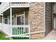 Exterior shot of a patio, showing the stone column and white railing at 18103 E Kentucky Ave # 103, Aurora, CO 80017