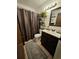 Bathroom featuring a dark vanity, modern fixtures, and a relaxing shower at 2034 S Truckee St, Aurora, CO 80013