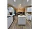 Bright kitchen with white cabinets, tile countertops, and an island with seating at 2034 S Truckee St, Aurora, CO 80013