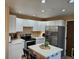 Spacious kitchen with stainless steel refrigerator and range, tile counters, and recessed lighting at 2034 S Truckee St, Aurora, CO 80013
