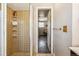 Bathroom featuring a tiled shower with glass door and view to the hallway at 16277 E Arkansas Dr, Aurora, CO 80017
