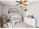 This cozy Bedroom features a crib, rocking chair and custom mountain theme wall decor creating a charming space at 16277 E Arkansas Dr, Aurora, CO 80017
