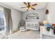 This cozy Bedroom features a crib, rocking chair and custom mountain theme wall decor creating a charming space at 16277 E Arkansas Dr, Aurora, CO 80017