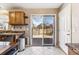 Kitchen featuring wood cabinets, dark countertops, and a sliding glass door to deck at 16277 E Arkansas Dr, Aurora, CO 80017