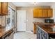 Kitchen featuring wood cabinets, dark countertops, and a view of the backyard at 16277 E Arkansas Dr, Aurora, CO 80017