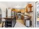 A kitchen featuring wood cabinets, stainless steel appliances, and a kitchen island with cook top at 16277 E Arkansas Dr, Aurora, CO 80017