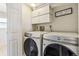 Clean laundry room with modern Samsung washer and dryer, and overhead storage cabinets at 16277 E Arkansas Dr, Aurora, CO 80017