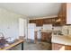 Outdated kitchen with dark cabinetry, dated appliances, and floral wallpaper at 1536 S Field Ct, Lakewood, CO 80232