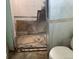 Close-up of damaged shower with missing tiles and dirty floor at 1536 S Field Ct, Lakewood, CO 80232
