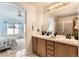 Bright bathroom featuring a double sink vanity, tiled floors, and an ensuite bedroom at 2444 S Scranton Way, Aurora, CO 80014