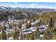 A high-angle shot of townhomes surrounded by a forest, with a snowy mountain range in the distance at 112 Illinois Gulch Rd # 6, Breckenridge, CO 80424