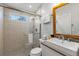 A well-lit bathroom featuring a glass enclosed shower, a sink with a gray countertop, and a wood-framed mirror at 112 Illinois Gulch Rd # 6, Breckenridge, CO 80424