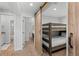 Stylish bedroom entryway featuring a sliding barn door leading to bunk beds with a full bath and bed in view at 112 Illinois Gulch Rd # 6, Breckenridge, CO 80424